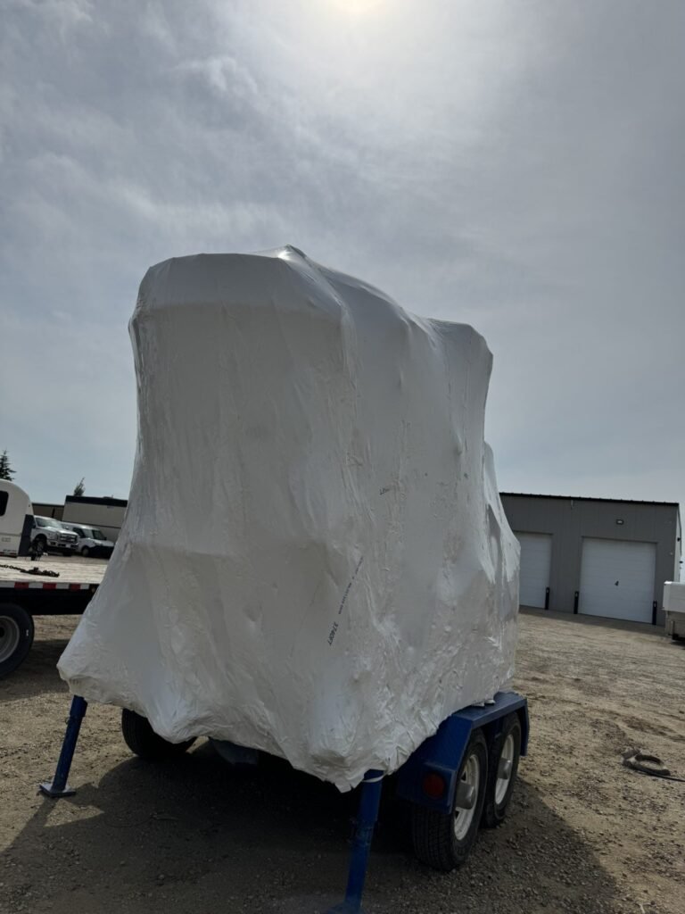 White shrink wrap seals trailer-mounted equipment.